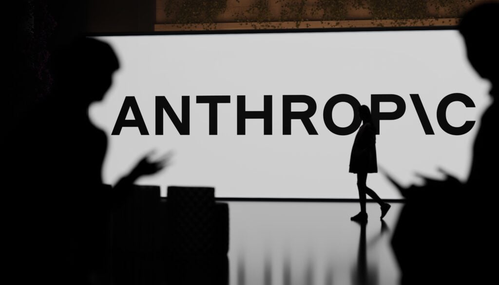 Vor dem großen Schriftzug Anthropic steht eine Person auf der Bühne, im Vordergrund sind Publikums-Silhouetten zu sehen.